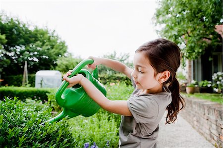 simsearch:649-05801200,k - Girl watering plants in backyard Foto de stock - Royalty Free Premium, Número: 649-05801132