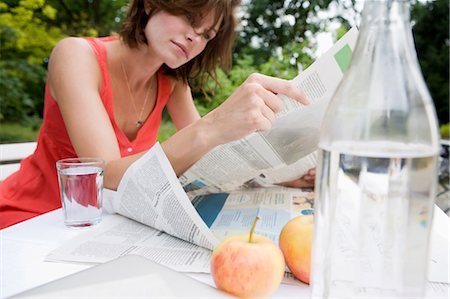 Woman reading newspaper in backyard Stock Photo - Premium Royalty-Free, Code: 649-05801161