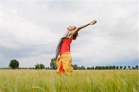 Femme souriante debout dans les hautes herbes Photographie de stock - Premium Libres de Droits, Code: 649-05801204