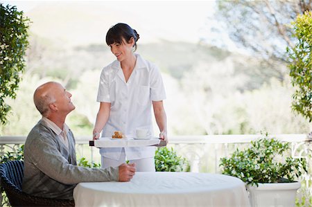 standing on terrace - Waitress serving older man coffee Stock Photo - Premium Royalty-Free, Code: 649-05801258