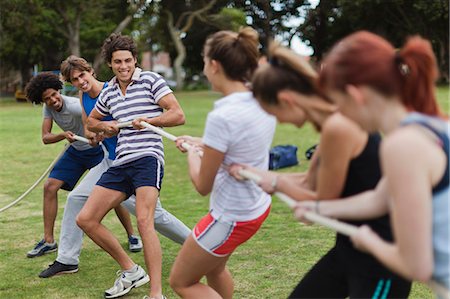 Friends playing tug of war in park Stock Photo - Premium Royalty-Free, Code: 649-05801425
