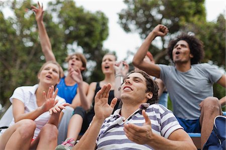 friends smiling group - Friends cheering at sporting event Stock Photo - Premium Royalty-Free, Code: 649-05801427