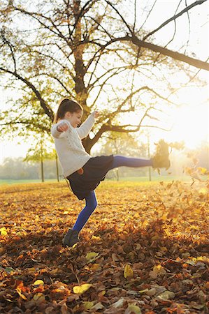 patear - Smiling girl playing in autumn leaves Foto de stock - Sin royalties Premium, Código: 649-05801613