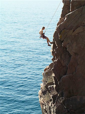 en descenso - Rock climber rappelling down rock face Foto de stock - Sin royalties Premium, Código: 649-05801689