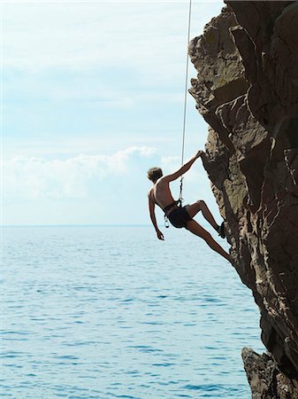 Rock climber rappelling down rock face Foto de stock - Sin royalties Premium, Código: 649-05801690