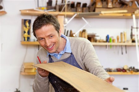 Carpenter examining sheet of wood Foto de stock - Sin royalties Premium, Código: 649-05801741