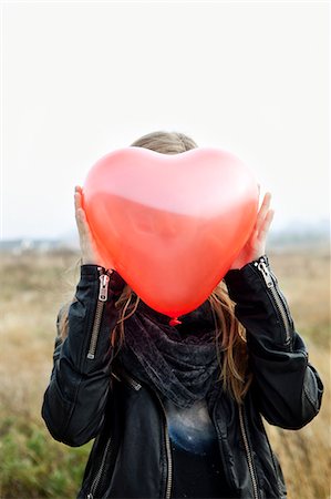 shy people - Girl holding heart-shaped balloon Stock Photo - Premium Royalty-Free, Code: 649-05801788