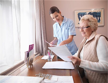 Older woman and nurse reading papers Foto de stock - Sin royalties Premium, Código: 649-05801949