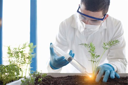 Scientist planting with glowing liquid Stock Photo - Premium Royalty-Free, Code: 649-05802377