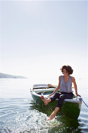 sunlight lake - Woman dangling feet from boat in lake Stock Photo - Premium Royalty-Free, Code: 649-05819838