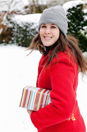 simsearch:6113-07906626,k - Woman carrying wrapped gift in snow Foto de stock - Royalty Free Premium, Número: 649-05819933