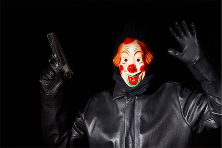 simsearch:649-06113680,k - Man in clown mask holding gun Fotografie stock - Premium Royalty-Free, Codice: 649-05820029