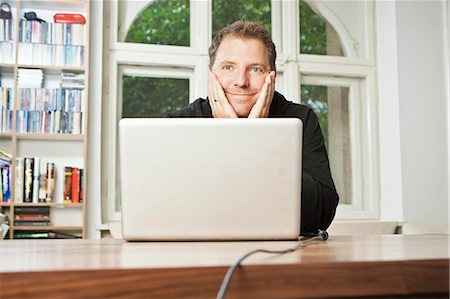 escapism - Man at computer with chin in hands Stock Photo - Premium Royalty-Free, Code: 649-05820275