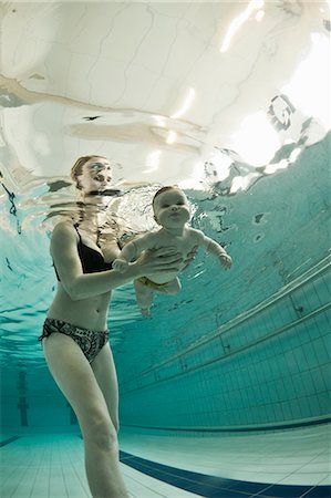 family underwater in a pool - Woman teaching baby to swim in pool Stock Photo - Premium Royalty-Free, Code: 649-05820408