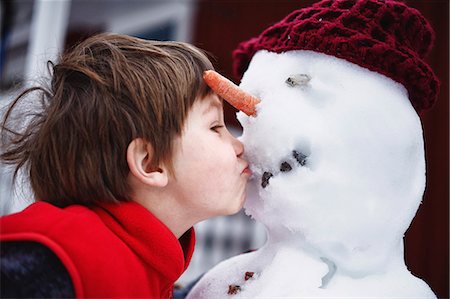 friends snow - Close up of boy kissing snowman Stock Photo - Premium Royalty-Free, Code: 649-05820494