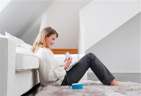 Woman shopping online in living room Stock Photo - Premium Royalty-Free, Code: 649-05820574