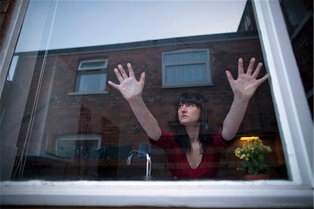 scared woman - Woman in kitchen leaning on window Stock Photo - Premium Royalty-Free, Code: 649-05820642