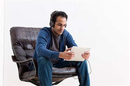 email white background - Man listening to tablet computer Stock Photo - Premium Royalty-Free, Code: 649-05820800