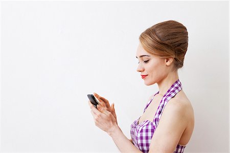 Smiling woman using cell phone Stock Photo - Premium Royalty-Free, Code: 649-05820869