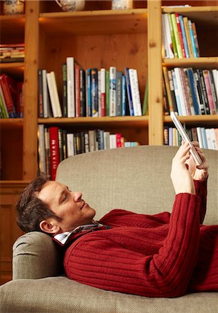 e-books - Mann Lesebuch auf sofa Stockbilder - Premium RF Lizenzfrei, Bildnummer: 649-05821027