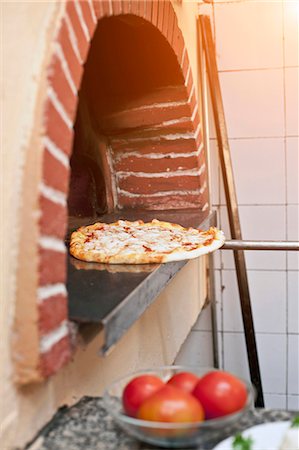 Chef pulling pizza from oven Stock Photo - Premium Royalty-Free, Code: 649-05821477