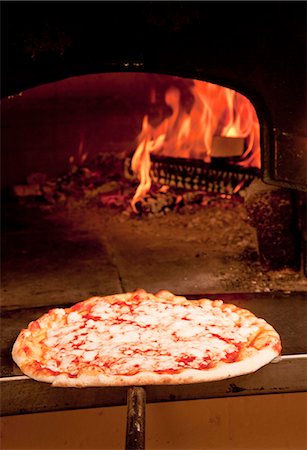 pizza - Chef en tirant la pizza du four Photographie de stock - Premium Libres de Droits, Code: 649-05821478