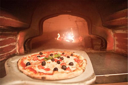 pizza - Chef pulling pizza from oven Foto de stock - Sin royalties Premium, Código: 649-05821483