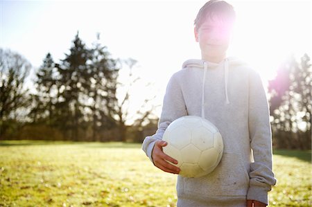 football field - Garçon transportant le ballon de soccer dans la prairie Photographie de stock - Premium Libres de Droits, Code: 649-05949499
