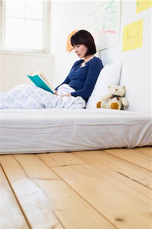 sentar - Woman reading book in bed Foto de stock - Royalty Free Premium, Número: 649-05949809