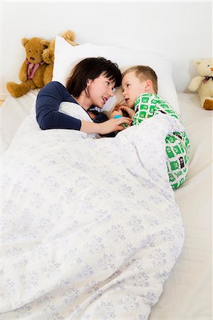 pyjama - Mère et fils pose dans son lit Photographie de stock - Premium Libres de Droits, Code: 649-05949803