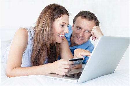 simsearch:6113-08943591,k - Couple shopping online on bed Stock Photo - Premium Royalty-Free, Code: 649-05949929