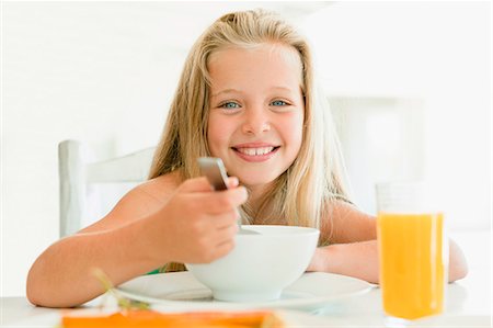 Girl eating cereal at breakfast table Stock Photo - Premium Royalty-Free, Code: 649-05949952