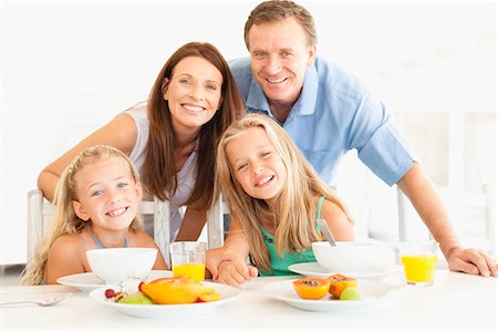 Famille souriant à la table du petit déjeuner Photographie de stock - Premium Libres de Droits, Code: 649-05949963