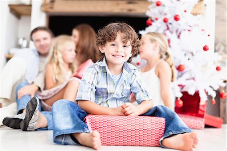 families opening presents at christmas - Boy sitting with wrapped Christmas gift Stock Photo - Premium Royalty-Free, Code: 649-05949991