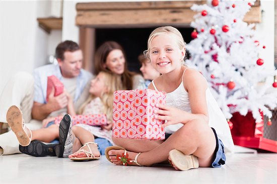 Girl sitting with wrapped Christmas gift Stock Photo - Premium Royalty-Free, Image code: 649-05949992