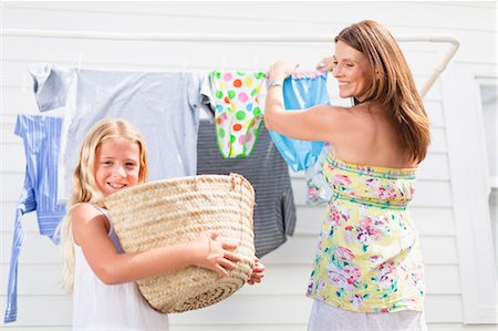 Girl helping mother hang laundry Stock Photo - Premium Royalty-Free, Code: 649-05950004