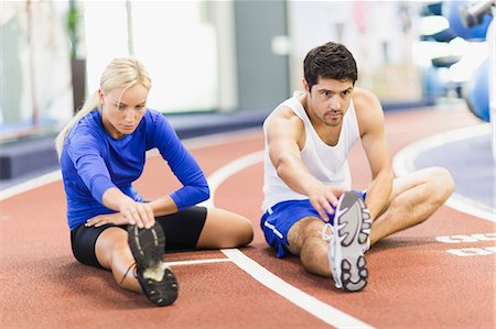 stretching (people exercising) - Couple stretching on indoor track in gym Stock Photo - Premium Royalty-Free, Code: 649-05950184