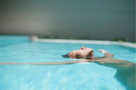 Woman floating in swimming pool Stock Photo - Premium Royalty-Free, Code: 649-05950456