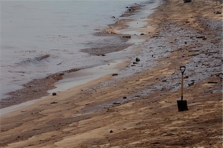 singapore environmental issues - Shovel in sand on oily beach Stock Photo - Premium Royalty-Free, Code: 649-05950458