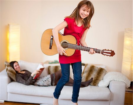 fin de semana - Girl playing guitar in living room Foto de stock - Sin royalties Premium, Código: 649-05950575
