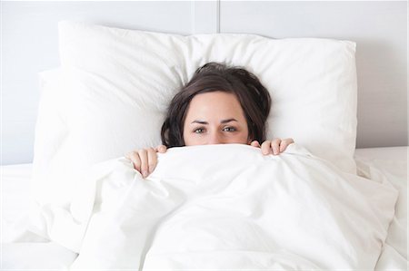 Woman hiding under covers in bed Foto de stock - Sin royalties Premium, Código: 649-05950674