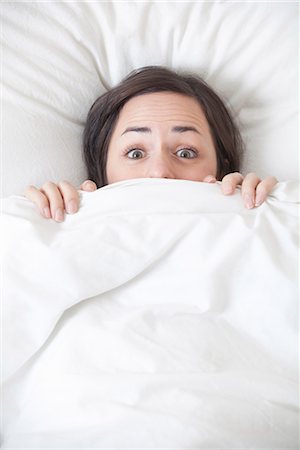 female surprised - Woman hiding under covers in bed Stock Photo - Premium Royalty-Free, Code: 649-05950675