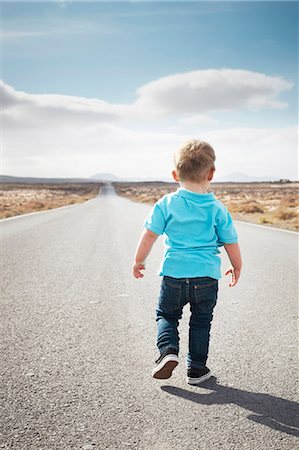 desert road landscape - Boy walking on paved rural road Stock Photo - Premium Royalty-Free, Code: 649-05950796