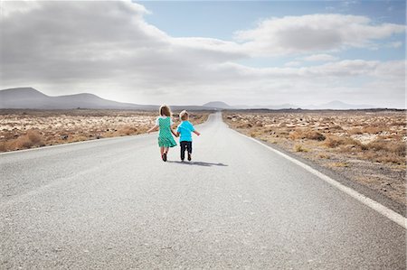 freedom not looking at camera horizontal - Children walking on paved rural road Stock Photo - Premium Royalty-Free, Code: 649-05950798