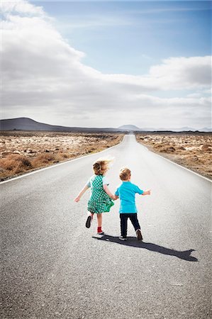 Enfants marchant sur une route pavée en milieu rural Photographie de stock - Premium Libres de Droits, Code: 649-05950799