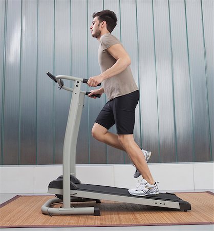 fit person running low angle - Man using exercise machine Stock Photo - Premium Royalty-Free, Code: 649-05951330
