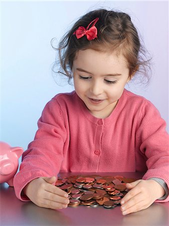 pièce (monnaie) - Fille jouant avec des tas de pièces de monnaie Photographie de stock - Premium Libres de Droits, Code: 649-06000345