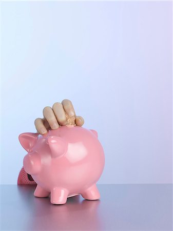 Girl putting coin in piggy bank Stock Photo - Premium Royalty-Free, Code: 649-06000342