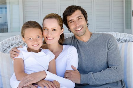 portrait of a daughter hugging her father - Family relaxing on sofa together Foto de stock - Sin royalties Premium, Código: 649-06000363