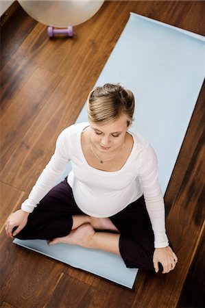 Pregnant woman practicing yoga on mat Foto de stock - Sin royalties Premium, Código: 649-06000436